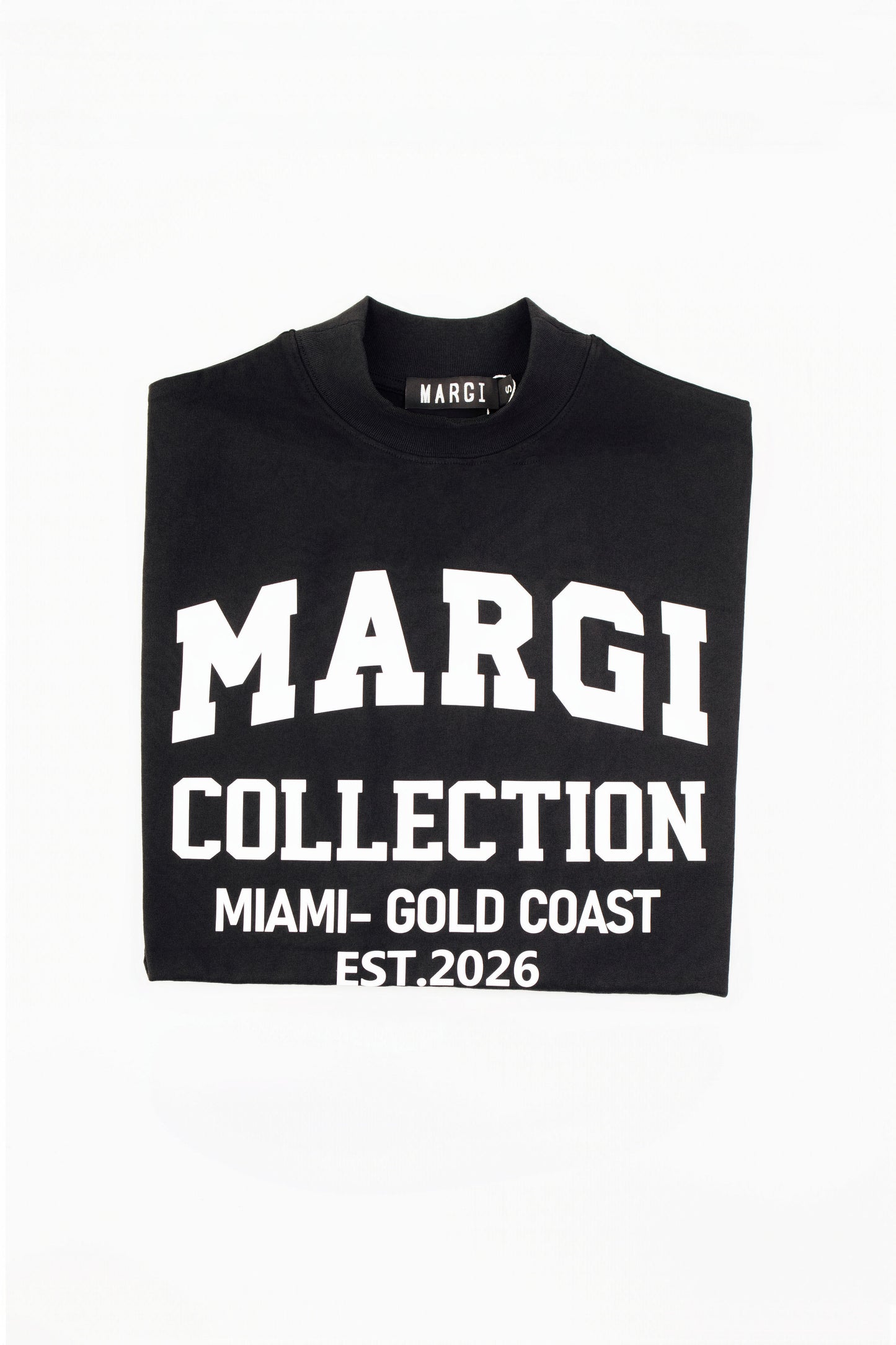 A folded black t-shirt with bold white text reading 'MARGI COLLECTION', 'MIAMI - GOLD COAST', and 'EST. 2026' on a plain white background.